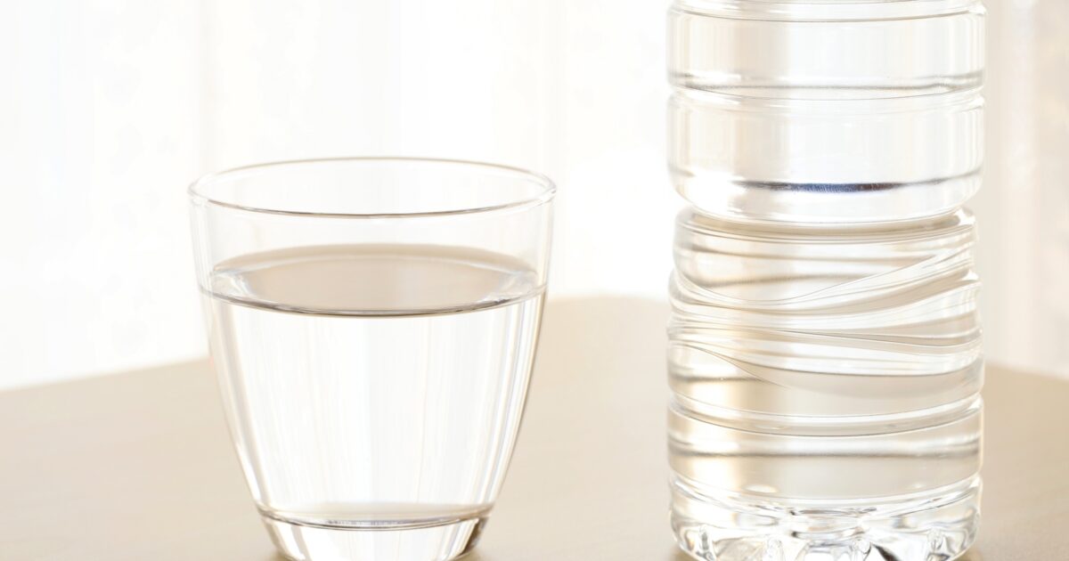ペットボトルの水とガラスのコップ