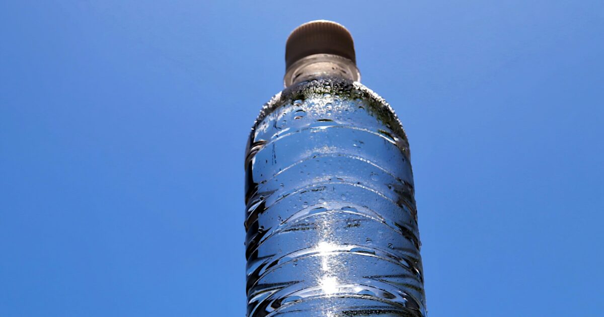 青空の下の冷たいペットボトルの水