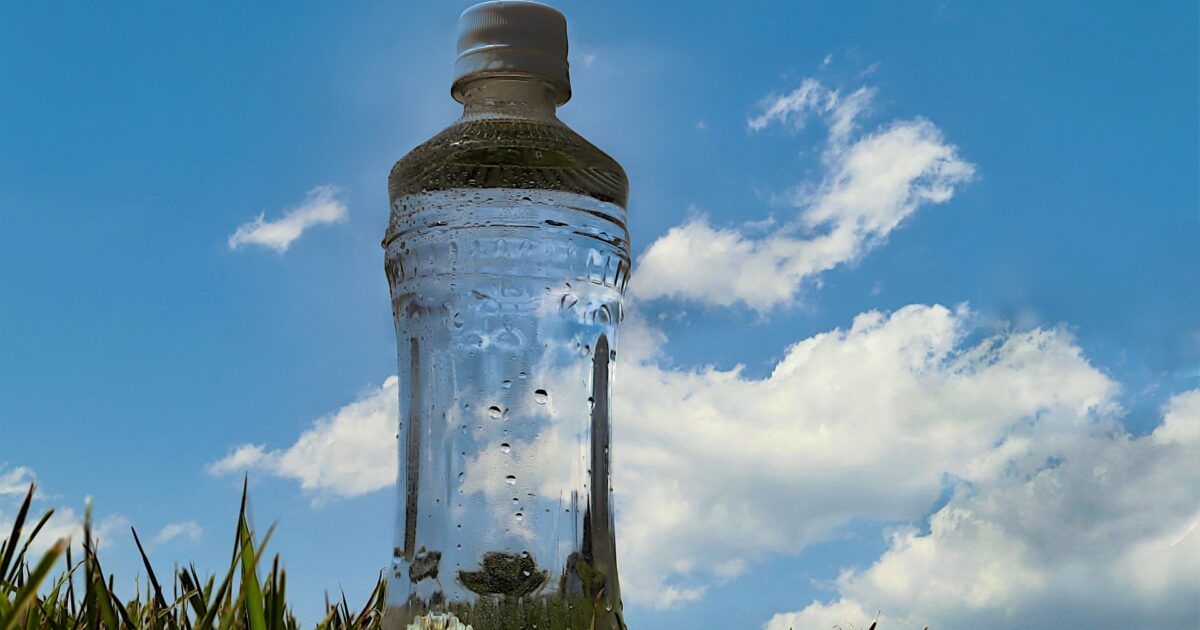 草むらに置かれた水滴のついたペットボトル