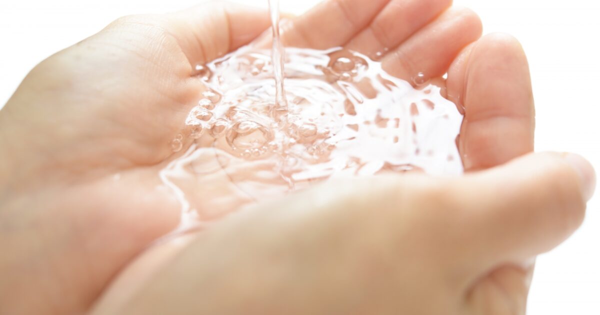 両手ですくった清潔な流水のクローズアップ