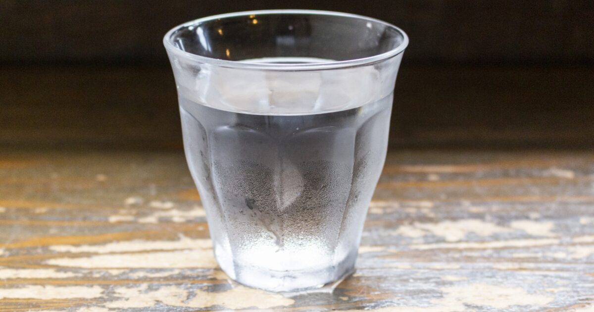 木製テーブルに置かれた氷水の入ったグラス