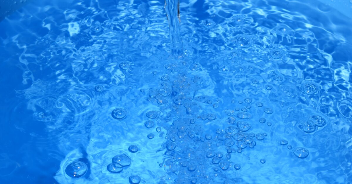 青いバケツに注がれる水と気泡