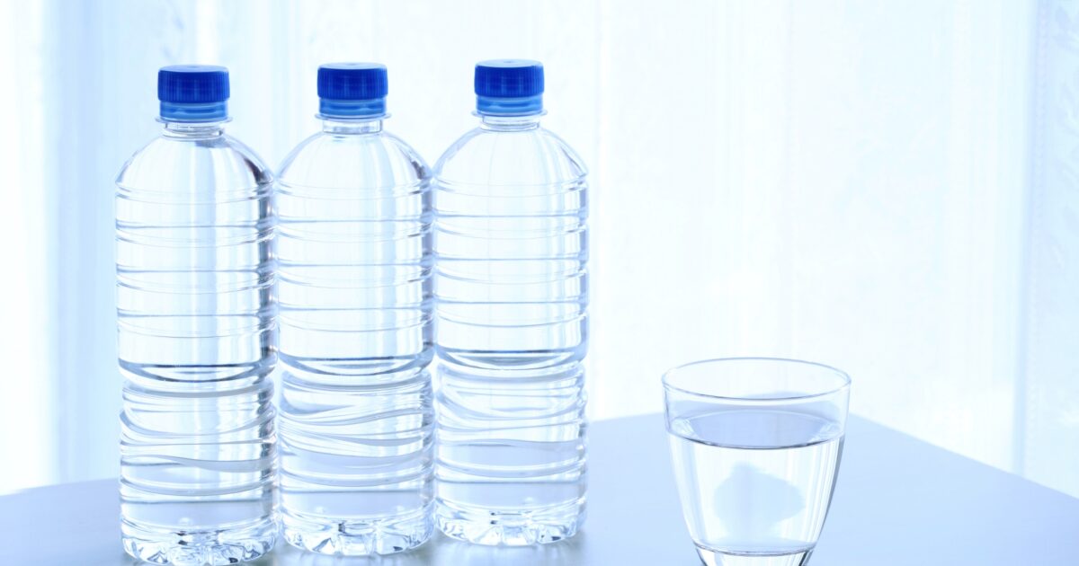 テーブルの上のペットボトルの水とコップ