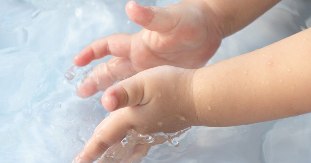 水遊び中の子供の手と水しぶき