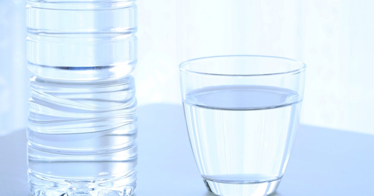 ペットボトルとコップの水のクローズアップ